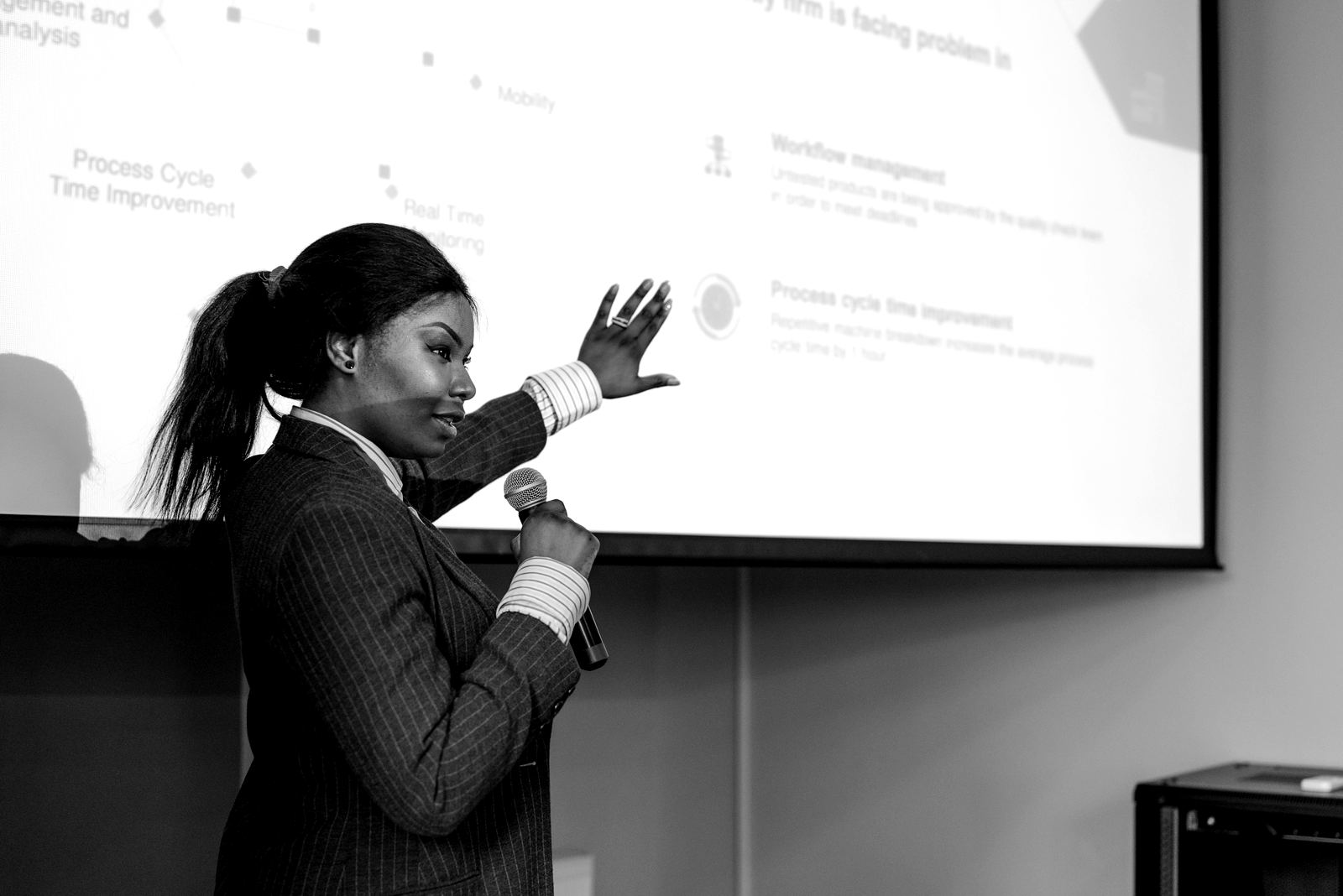 A speaker presenting a workflow diagram on screen during a workshop