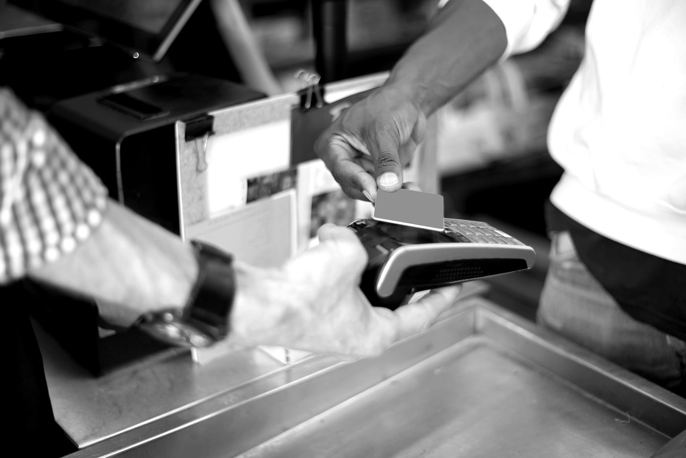 A customer paying by card at a shop counter