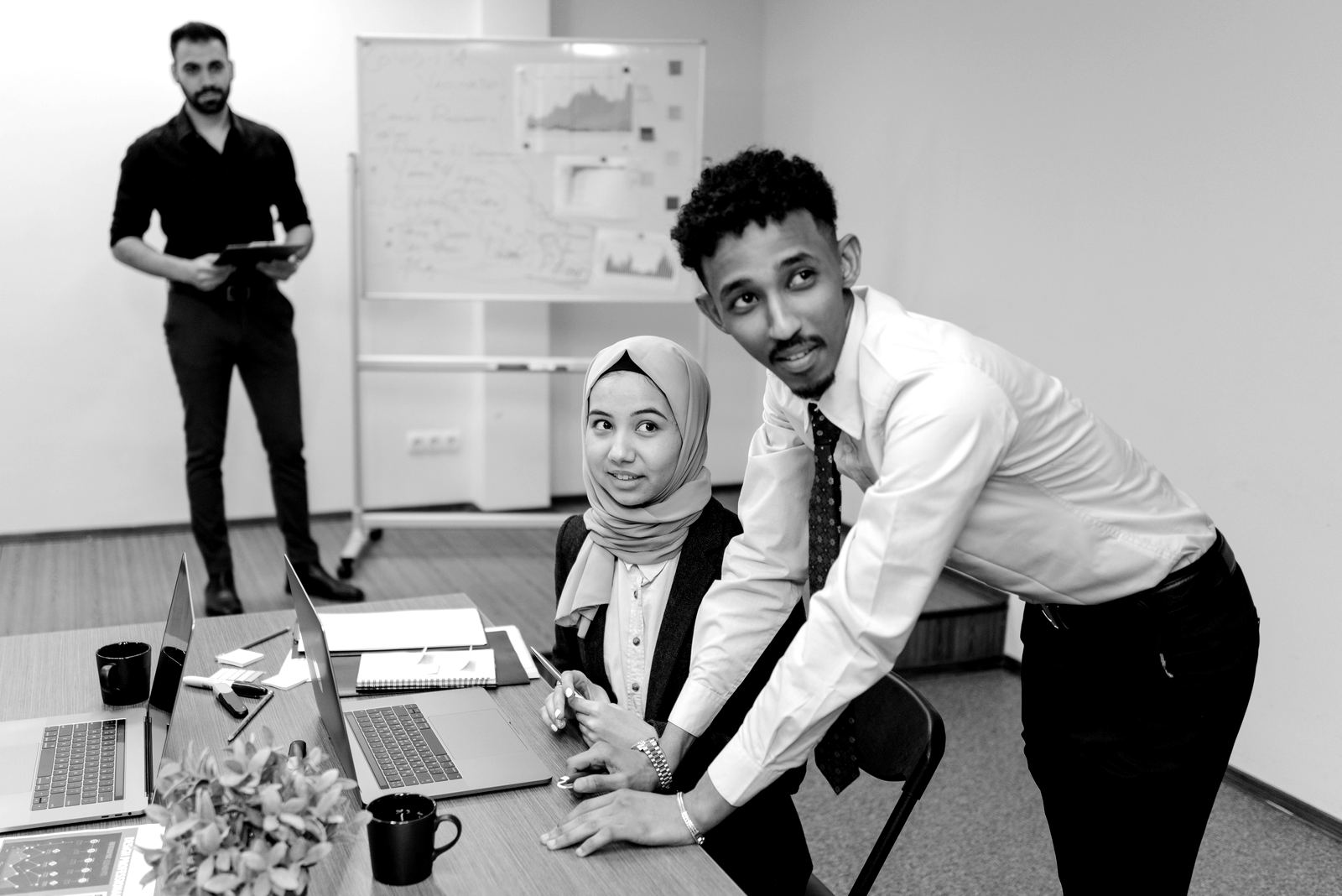Young professionals working together at laptops in an office